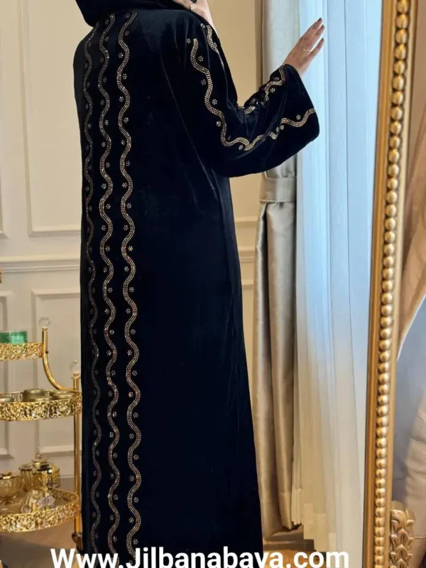 Elegant black velvet abaya with intricate golden embroidery displayed from the back.